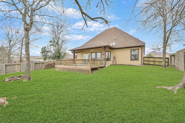 rear view of house with a deck and a yard