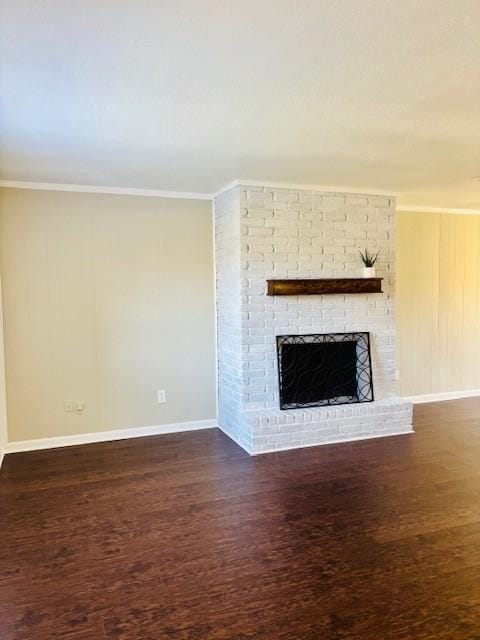 unfurnished living room with a brick fireplace, ornamental molding, and dark hardwood / wood-style flooring