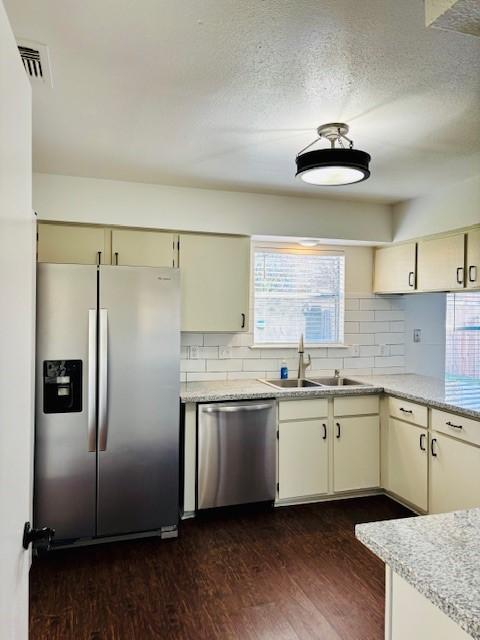 kitchen featuring dark wood-type flooring, cream cabinetry, appliances with stainless steel finishes, and sink