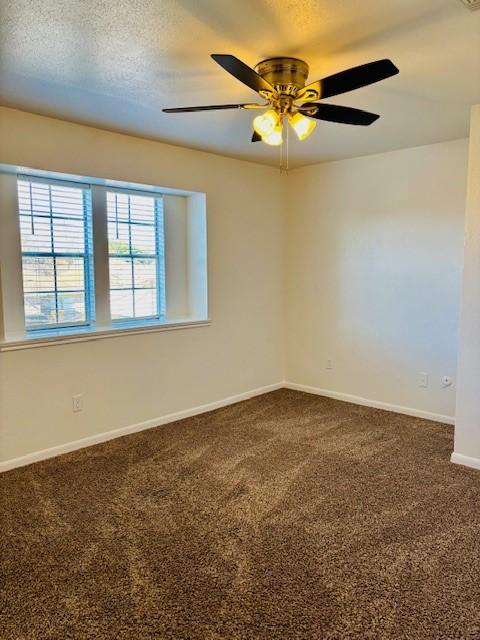 carpeted empty room featuring ceiling fan and a textured ceiling