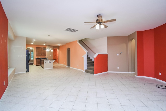 unfurnished living room with ceiling fan with notable chandelier and sink