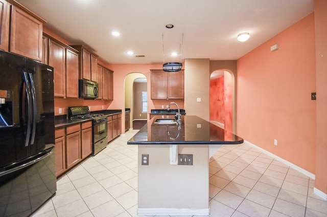 kitchen featuring sink, black appliances, a kitchen island with sink, and light tile patterned floors