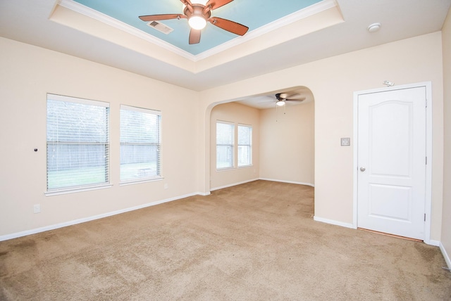 carpeted spare room featuring ceiling fan and a raised ceiling