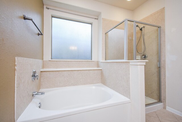 bathroom featuring a wealth of natural light, independent shower and bath, and tile patterned flooring