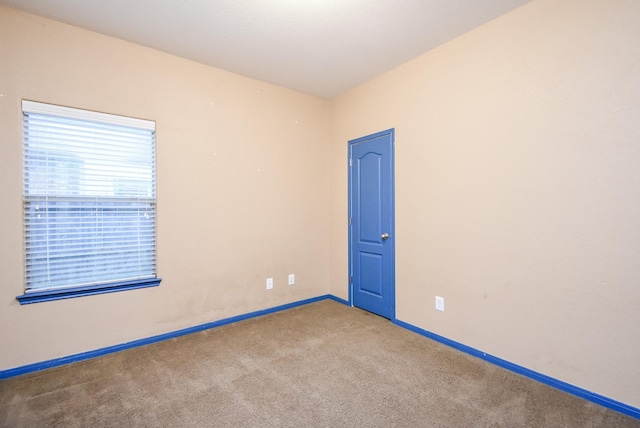 unfurnished room featuring carpet flooring and baseboards