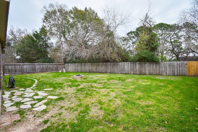 view of yard featuring an outdoor fire pit and a fenced backyard