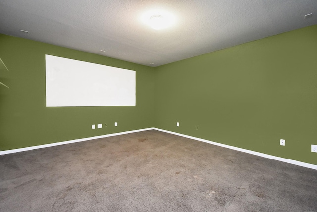 unfurnished room with carpet and a textured ceiling