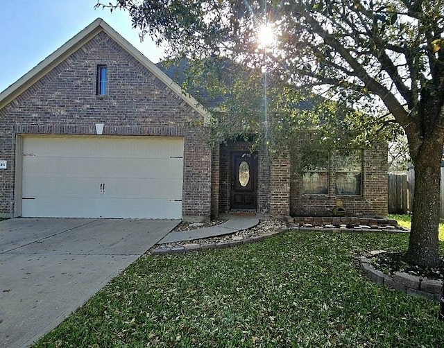 view of front of home featuring brick siding, an attached garage, concrete driveway, and a front lawn