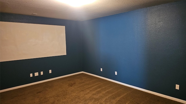 carpeted empty room with baseboards and a textured ceiling