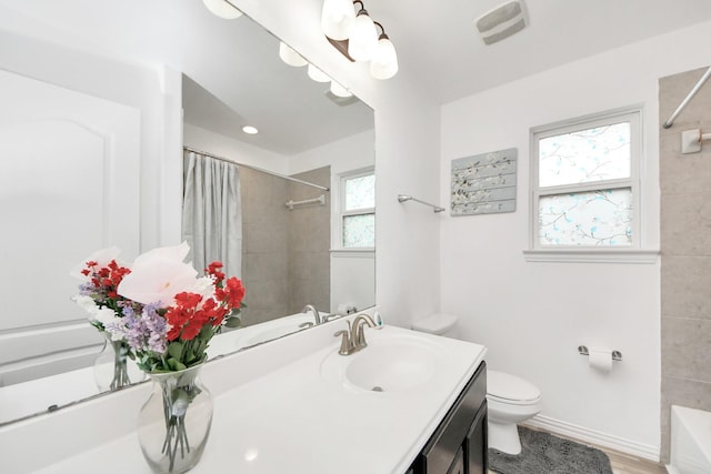 full bathroom featuring vanity, toilet, plenty of natural light, and wood-type flooring