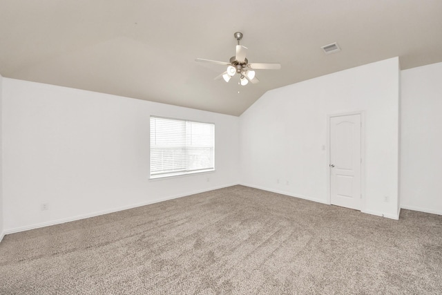 empty room featuring vaulted ceiling, carpet, and ceiling fan