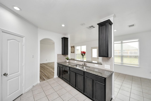 kitchen with sink, plenty of natural light, light tile patterned floors, and light stone countertops