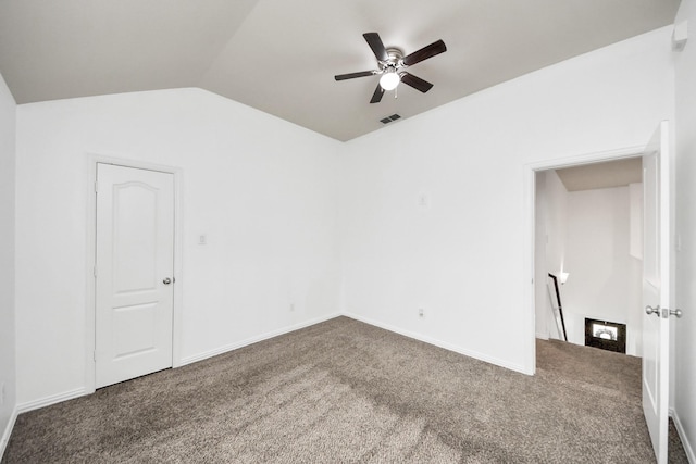 empty room with ceiling fan, lofted ceiling, and dark colored carpet