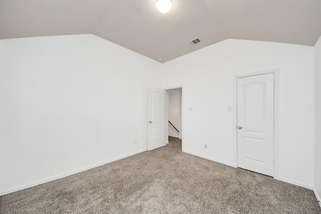 unfurnished bedroom featuring carpet and vaulted ceiling