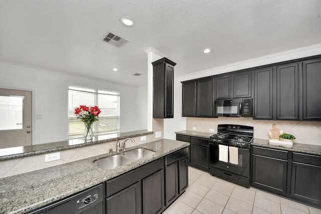 kitchen featuring sink, tasteful backsplash, light stone countertops, light tile patterned flooring, and black appliances