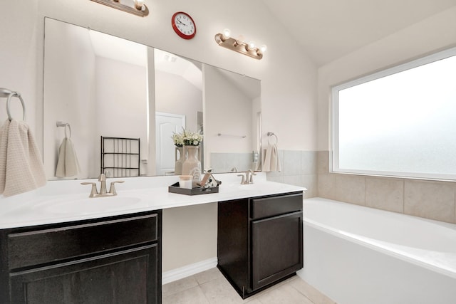 bathroom featuring a washtub, vaulted ceiling, tile patterned floors, and vanity