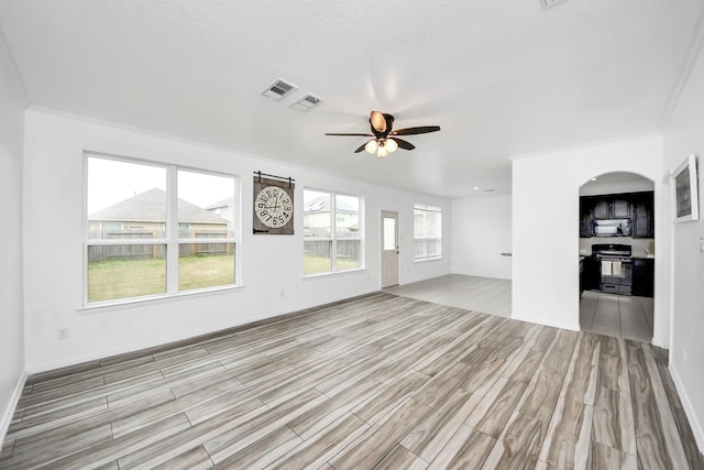 unfurnished living room featuring ceiling fan and crown molding