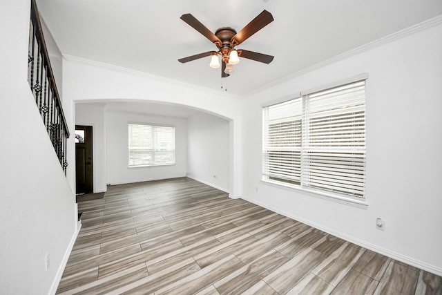 unfurnished living room with ceiling fan and ornamental molding