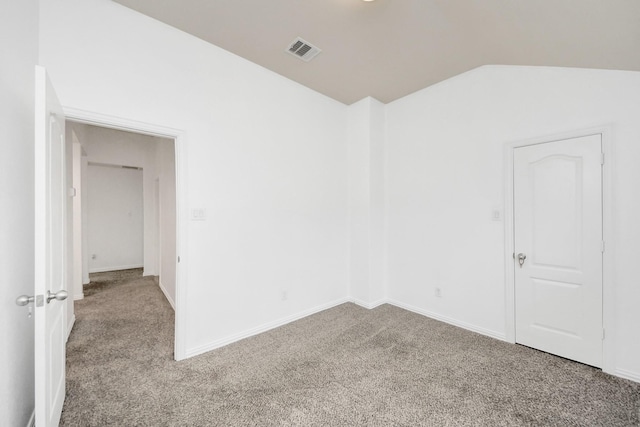 spare room with carpet floors and lofted ceiling