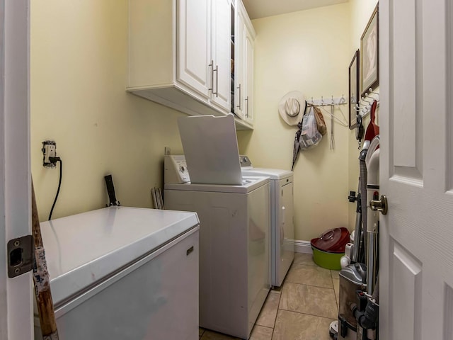 washroom with cabinets, washer and clothes dryer, and light tile patterned flooring