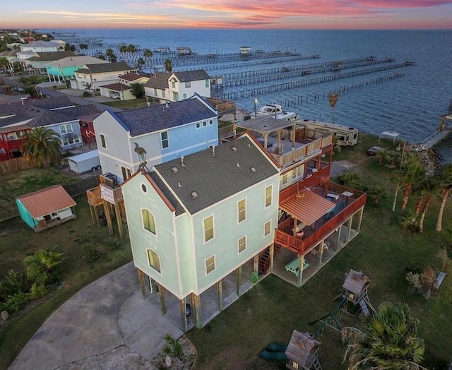 aerial view at dusk featuring a water view