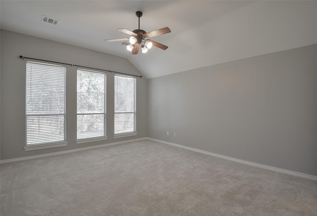 carpeted spare room with ceiling fan, a wealth of natural light, and vaulted ceiling