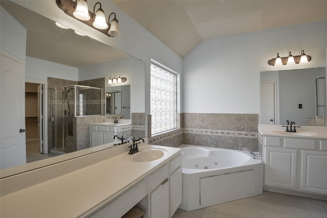 bathroom featuring vanity, independent shower and bath, and vaulted ceiling