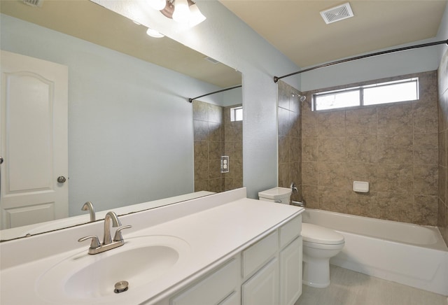 full bathroom featuring toilet, vanity, and tiled shower / bath