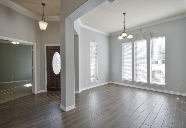 foyer entrance featuring plenty of natural light, crown molding, and a notable chandelier