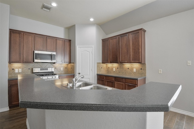 kitchen with sink, appliances with stainless steel finishes, and a center island with sink