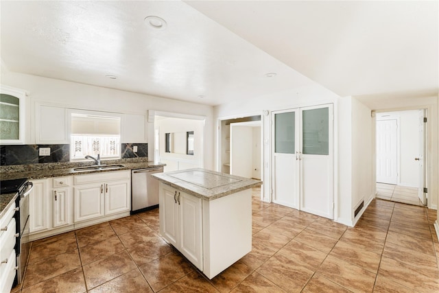 kitchen featuring stainless steel appliances, tasteful backsplash, a center island, white cabinets, and sink