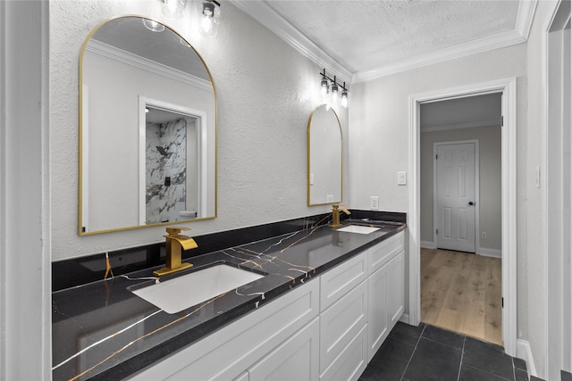 bathroom with a textured ceiling, crown molding, tile patterned floors, and vanity