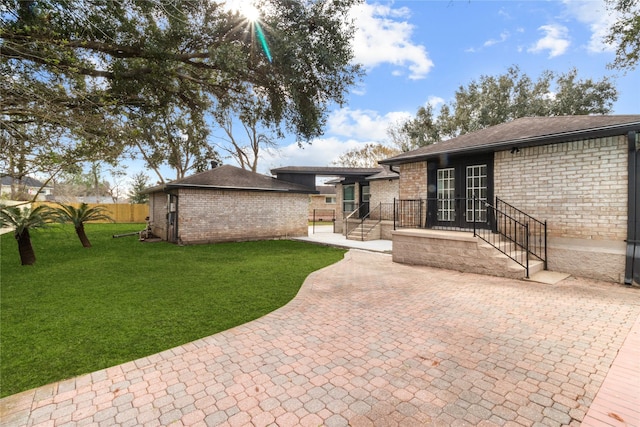 view of front of home with a front yard and a patio