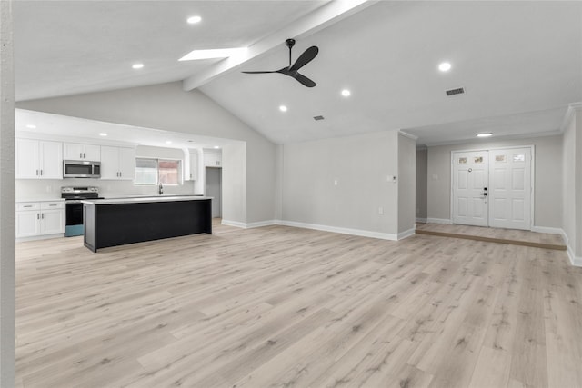 unfurnished living room featuring ceiling fan, light hardwood / wood-style floors, sink, and lofted ceiling with beams