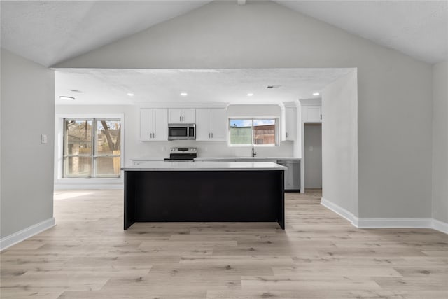 kitchen with white cabinets, a kitchen island, stainless steel appliances, and a textured ceiling