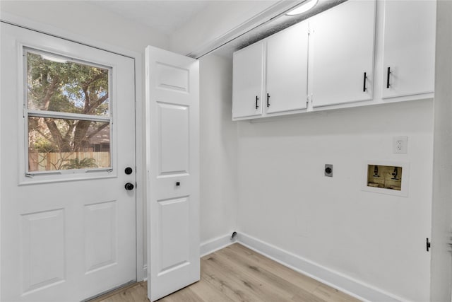 laundry area featuring a healthy amount of sunlight, light wood-type flooring, electric dryer hookup, and cabinets