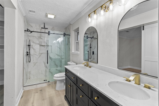 bathroom featuring a textured ceiling, a shower with door, vanity, toilet, and hardwood / wood-style flooring