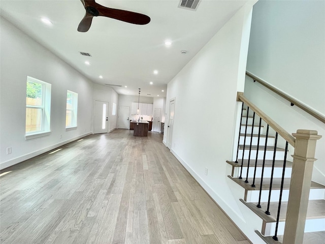 unfurnished living room featuring ceiling fan and light hardwood / wood-style flooring