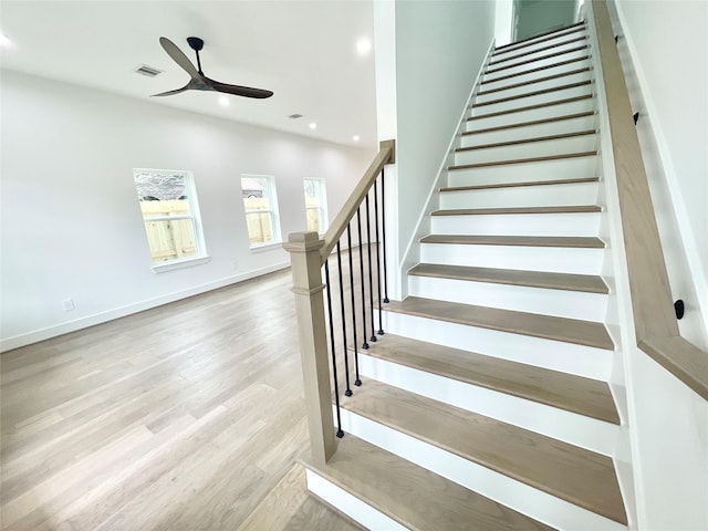 staircase featuring ceiling fan and wood-type flooring