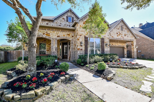 view of front of property featuring stone siding, concrete driveway, a garage, and fence