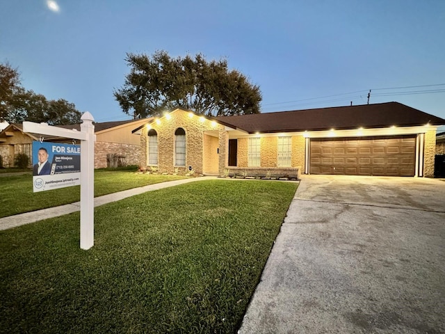 single story home with a garage and a yard