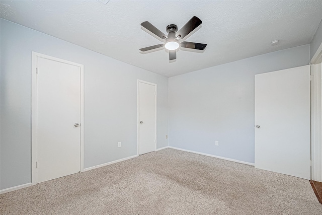 carpeted spare room with ceiling fan and a textured ceiling