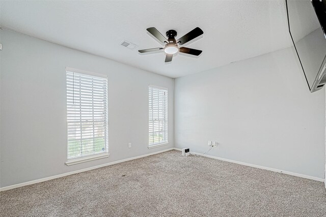 carpeted spare room featuring ceiling fan and a textured ceiling