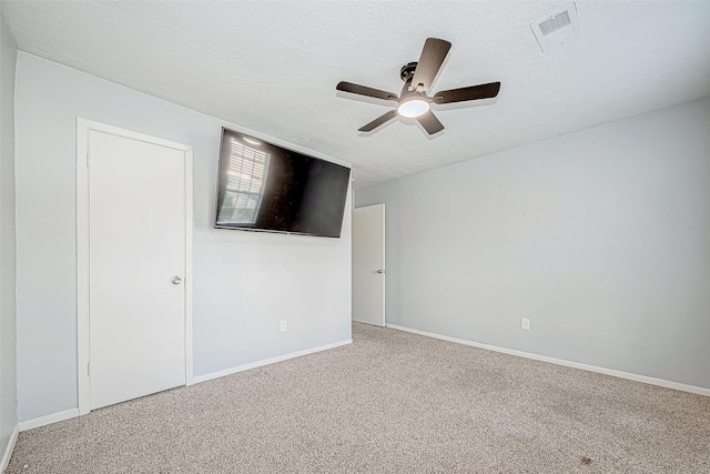 carpeted spare room with ceiling fan and a textured ceiling