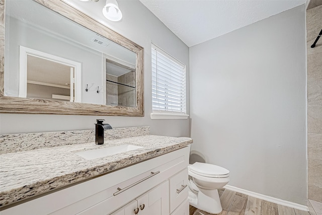 bathroom featuring vanity, hardwood / wood-style flooring, toilet, and walk in shower