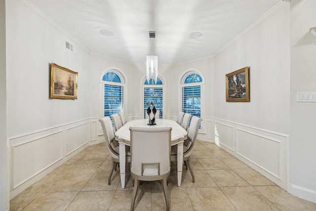 tiled dining space with crown molding and a textured ceiling