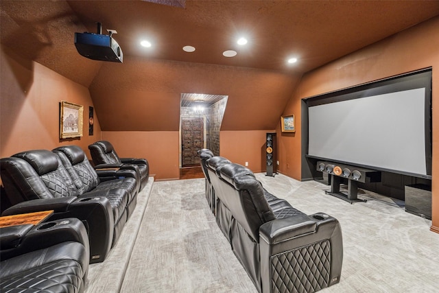 cinema room with vaulted ceiling, light carpet, and a textured ceiling