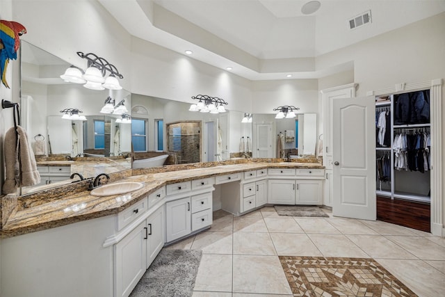 bathroom with a shower with shower door, a high ceiling, vanity, tile patterned flooring, and a raised ceiling