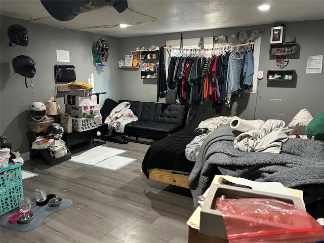 bedroom with a closet, a textured ceiling, and hardwood / wood-style flooring