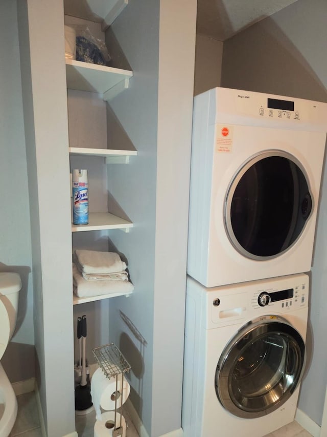 laundry area featuring tile patterned floors and stacked washer and dryer